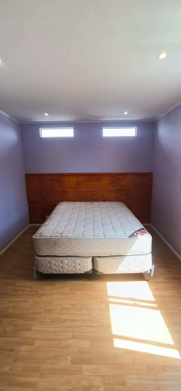 Dormitorio de segundo piso terminado con piso flotante y ventanales altos