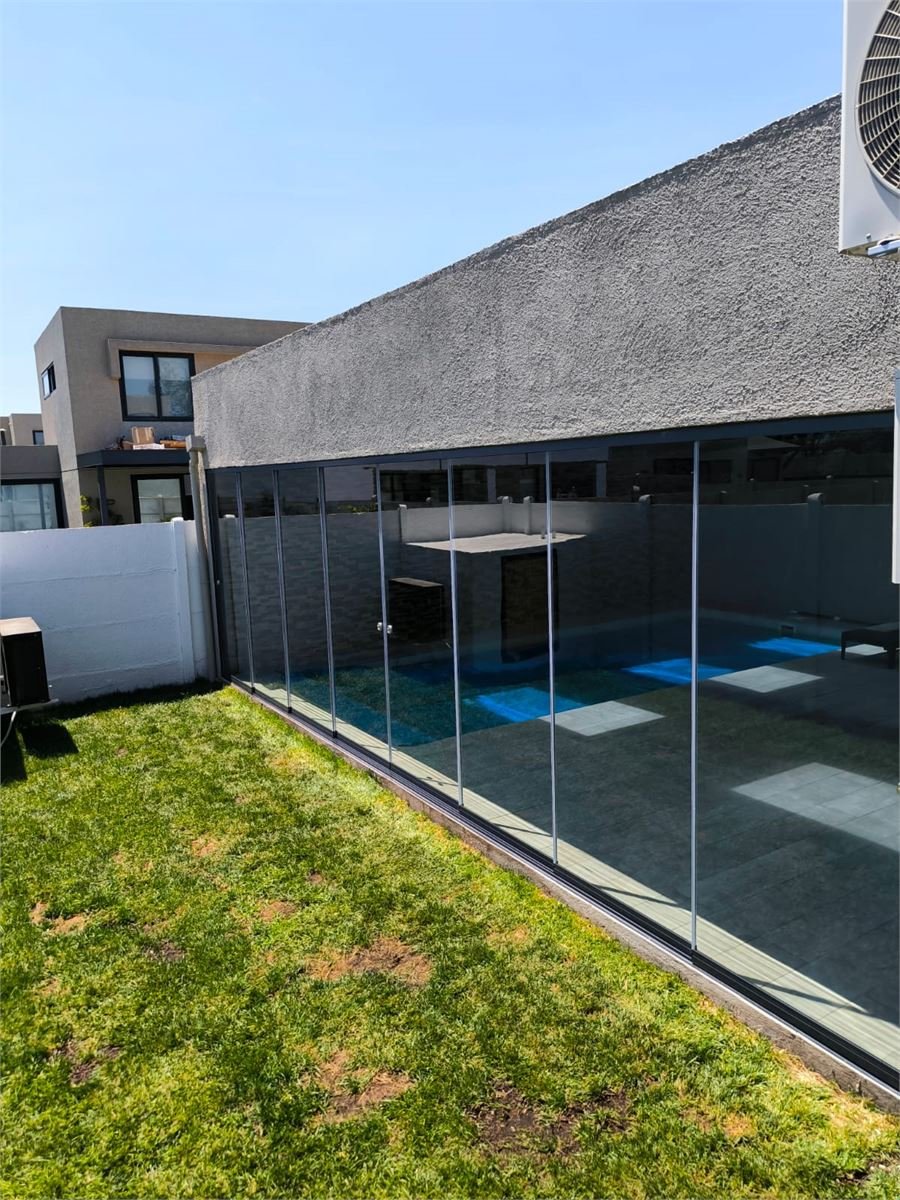 Fachada con grandes ventanales del recinto de piscina