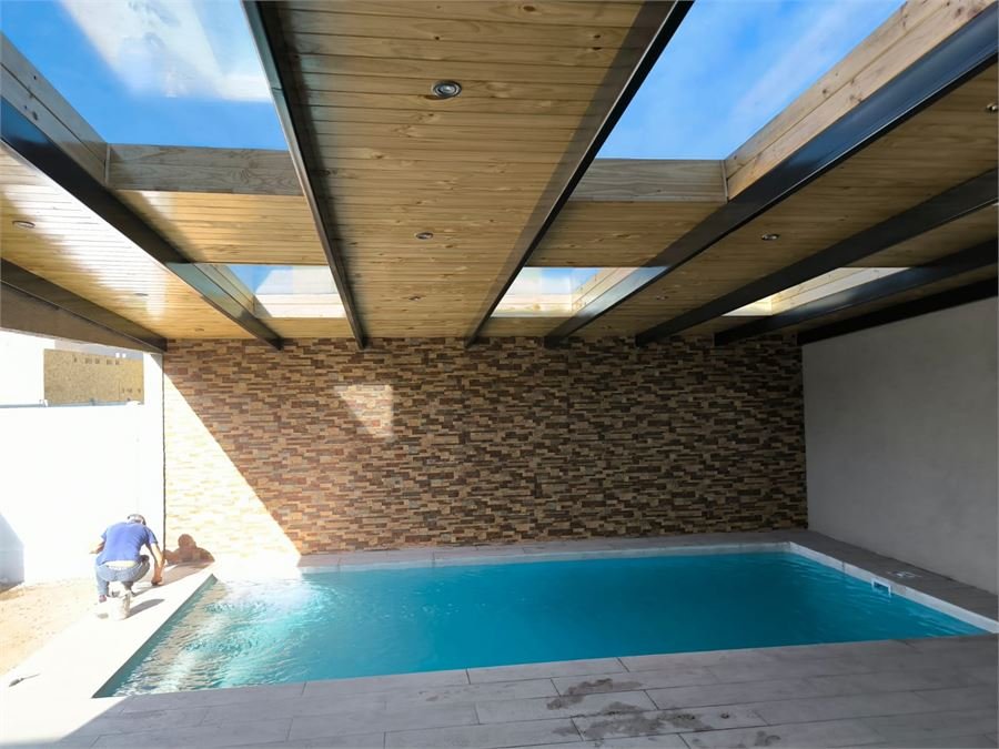 Piscina bajo cubierta de madera con lucernarios