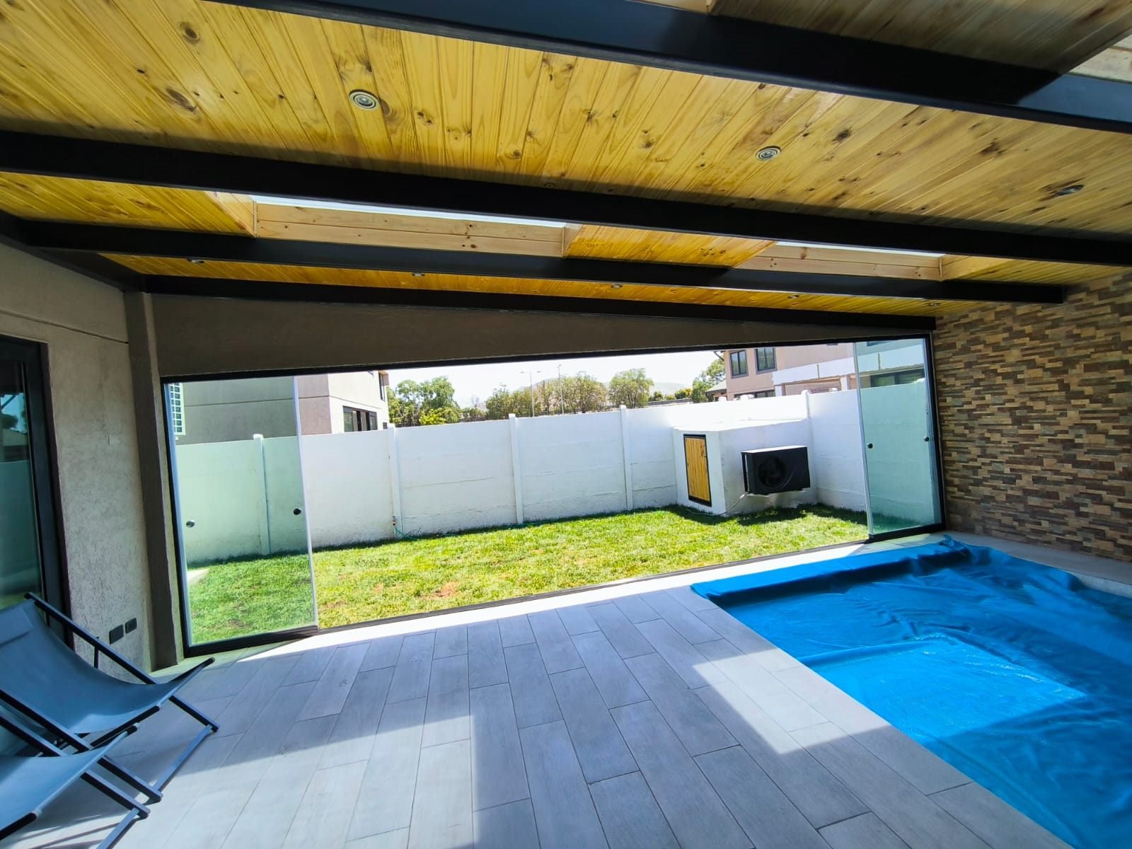 Terraza techada con piscina, quincho y salida al jardín